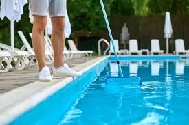 Skimming a pool in Frisco TX - Sparkling Clear Pool Service - Sparkling Clear Pool Service LLC Skimming debris from a Frisco, TX pool as part of weekly care